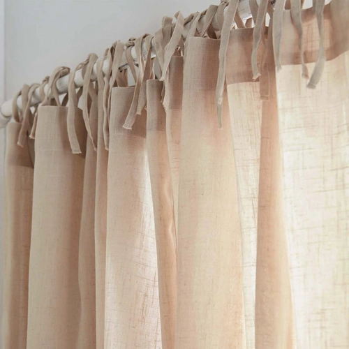 close-up of a tie-top curtain made of light, semi-sheer fabric in a natural or beige color.